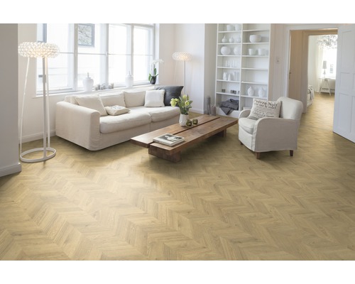 Cameră de zi luminoasă cu parchet herringbone, canapea, fotoliu, masă și raft