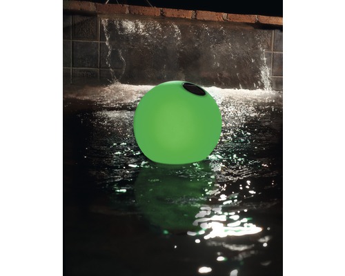 Lumină plutitoare verde în apă în fața unei cascade