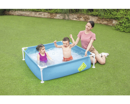 Scenă cu copii și un adult într-o piscină pentru copii în grădină.