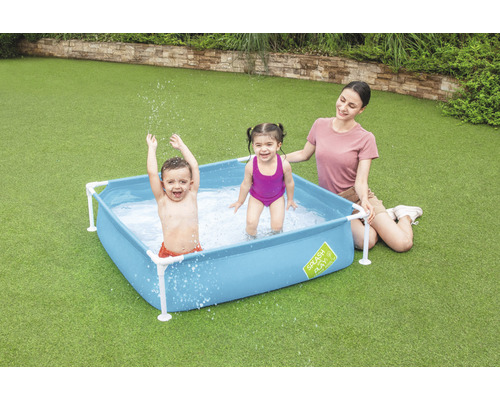 Familie cu copii în piscină albastră în grădină