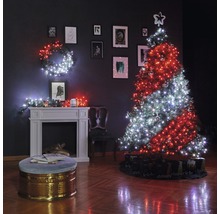 Sufragerie decorată de Crăciun cu brad, ghirlande luminoase, șemineu și tablouri pe perete.