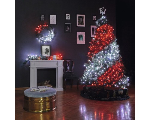 Sufragerie decorată de Crăciun cu brad, ghirlande luminoase, șemineu și tablouri pe perete.