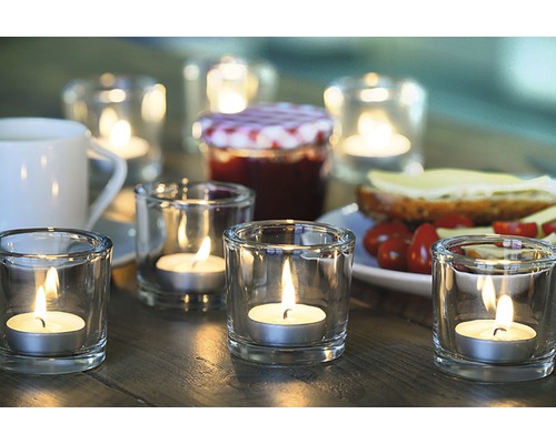 Decor de masă cu lumânări pastilă în pahare, borcan de gem și pâine cu topping