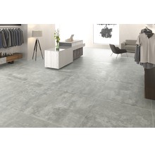 Cameră luminoasă cu gresie cu aspect de beton.