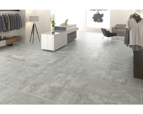 Cameră luminoasă cu gresie cu aspect de beton.