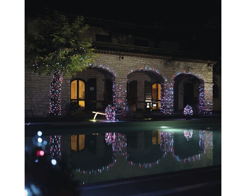 Casă de piatră cu grădină, iluminată cu un lanț luminos