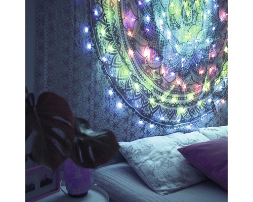 Dormitor cu tapiserie și ghirlandă luminoasă deasupra patului