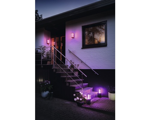 Fațadă de casă cu lumini de exterior iluminate pe perete și scări