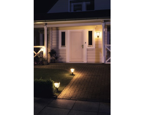 Zonă de intrare în casă iluminată cu potecă, gazon și lumini exterioare