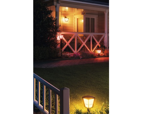 Casă iluminată cu corpuri de iluminat exterioare și grădină