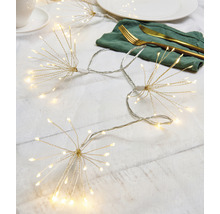 Scenă cu un șir de lumini în formă de stea, o farfurie, tacâmuri și o ceașcă