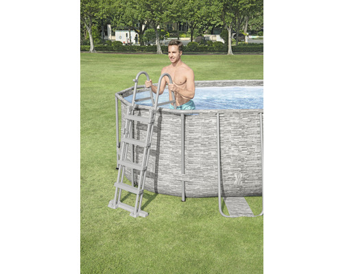 Piscină supraterană cu scară și bărbat în grădină.
