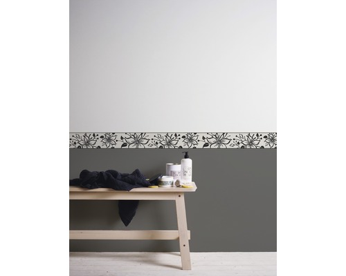 Design baie cu bordură florală, prosop și produse de îngrijire pe o bancă de lemn.