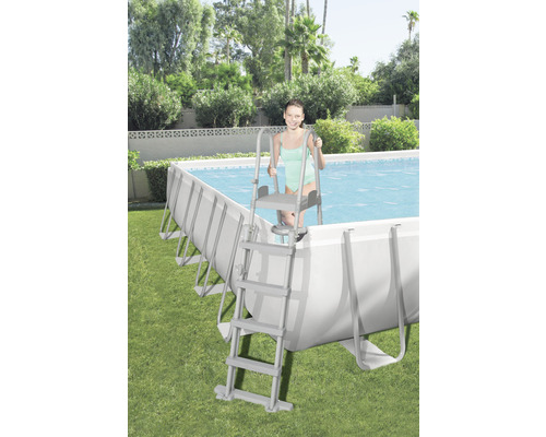 Piscină cu scară în grădină cu o tânără femeie