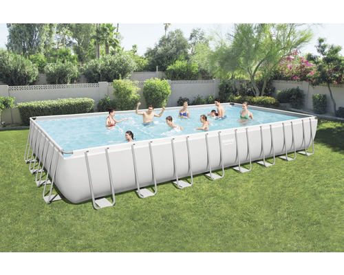 Piscină dreptunghiulară cu cadru de oțel în grădină cu oameni care se joacă.