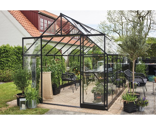 Seră cu plante și mobilier de grădină în aer liber.