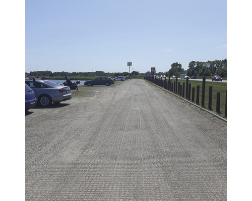 Parcare cu dale de gazon și mai multe vehicule parcate