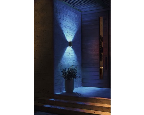 Zonă de intrare iluminată cu lampă de perete exterioară, ușă de intrare și scară