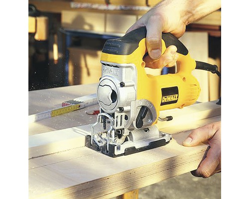 Persoană taie lemn cu un fierăstrău vertical marca DeWalt.