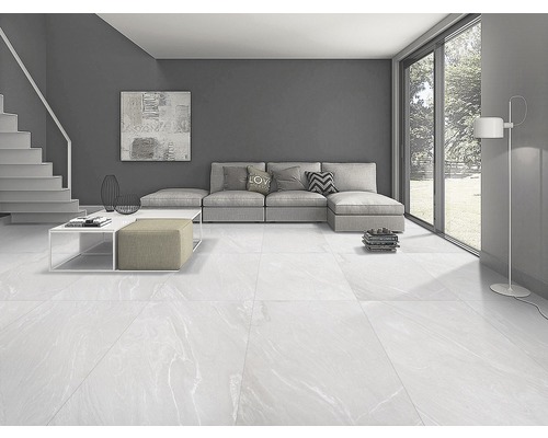 Cameră de zi luminoasă cu canapea, masă și podea cu gresie