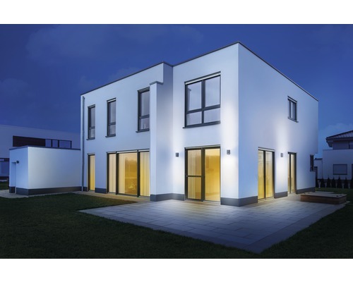 Casă modernă cu iluminat exterior în grădină pe timp de noapte