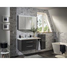 Baie modernă cu lavoar, dulap cu oglindă și cadă în fața unui perete cu model