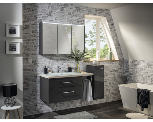 Baie modernă cu lavoar, dulap cu oglindă și cadă în fața unui perete cu model