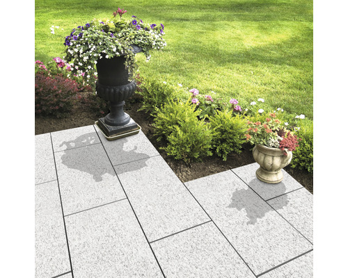 Alei de grădină cu pavaj deschis la culoare și jardiniere plantate