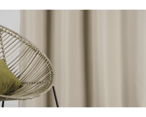 Șaluri decorative și scaun din ratan într-o cameră luminoasă.