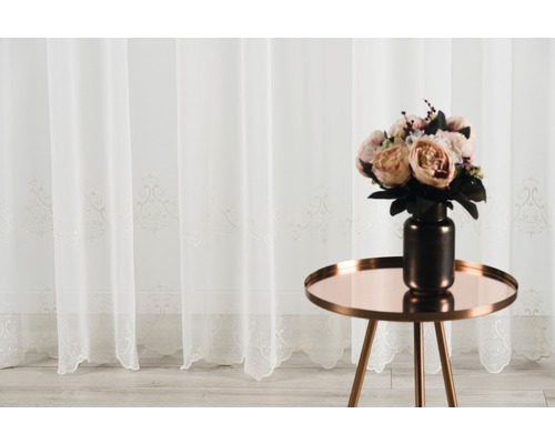 Șaluri decorative cu ornamente și un buchet de flori pe o masă