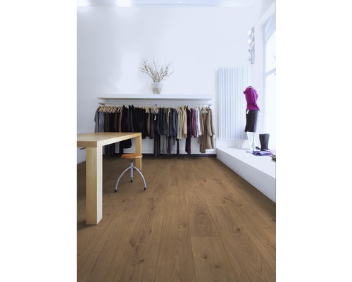 Cameră luminoasă cu podea laminată, masă, scaun și suport pentru haine