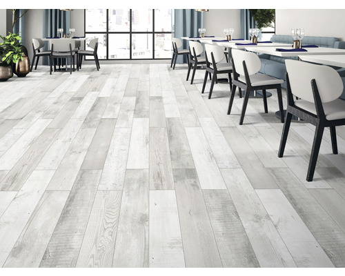 Podea deschisă la culoare, din lemn, într-un restaurant cu mese și scaune