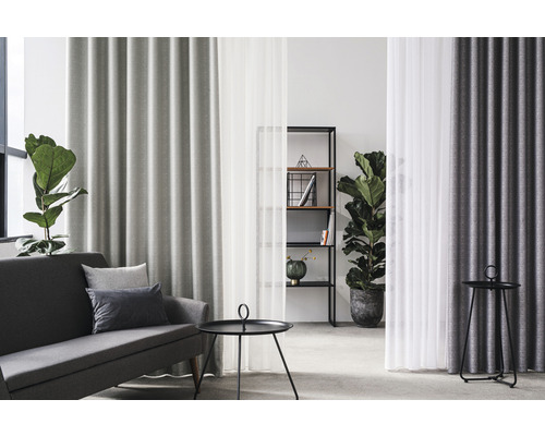 Cameră de zi cu canapea, masă și perdele pentru o atmosferă confortabilă.