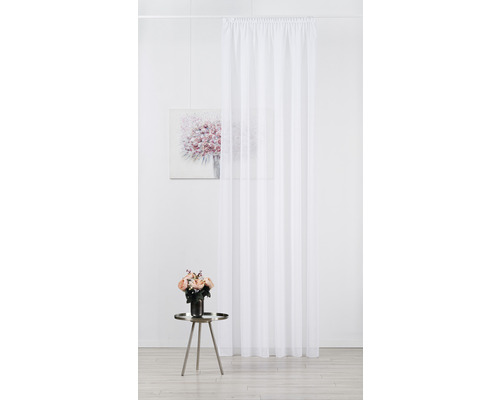 Perdea albă, transparentă, în fața unui perete cu decorațiuni