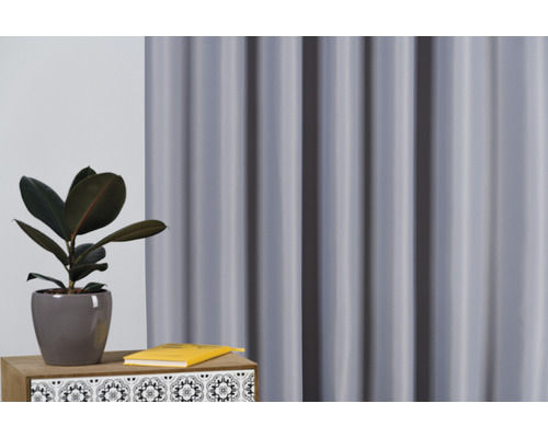 Aranjament decorativ cu perdea, plantă la ghiveci și carte pe o masă