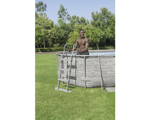 Piscină supraterană cu scară și persoană în picioare în grădină