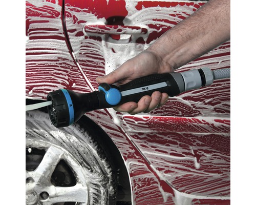 O persoană spală o mașină cu un pistol de pulverizare multifuncțional.