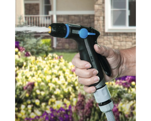 O mână ține un pulverizator de grădină și udă plantele.