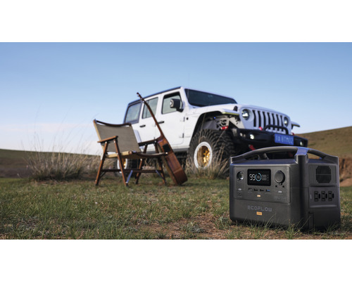 Centrală electrică Ecoflow River Pro în fața unei mașini, a unui scaun și a unei chitare pe o pajiște