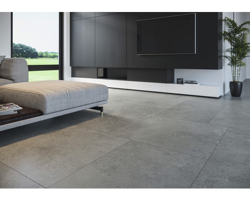 Cameră de zi luminoasă cu gresie gri, măsuță de cafea și perete TV