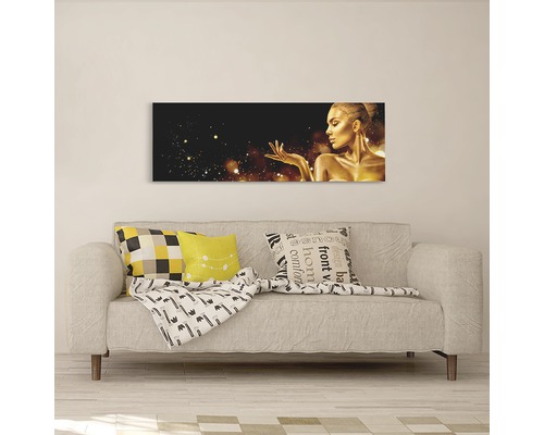 Tablou decorativ de perete cu o femeie aurie deasupra unei canapele