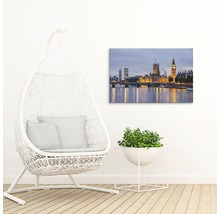 Pânză decorativă cu o imagine a clădirii Parlamentului din Londra deasupra unui râu, lângă un scaun suspendat și o plantă la ghiveci