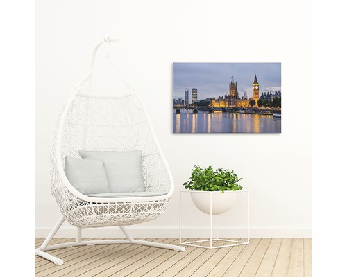 Pânză decorativă cu o imagine a clădirii Parlamentului din Londra deasupra unui râu, lângă un scaun suspendat și o plantă la ghiveci