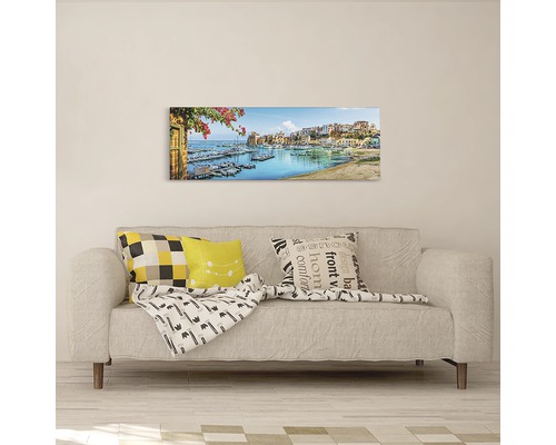 Tablou de perete cu motiv portuar deasupra unei canapele