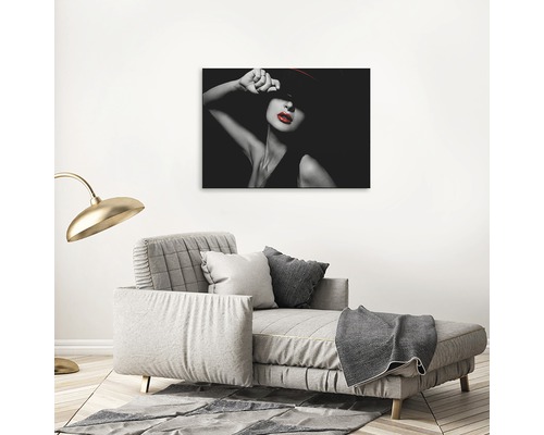 Pânză decorativă cu o femeie cu pălărie roșie și buze roșii deasupra unei canapele gri