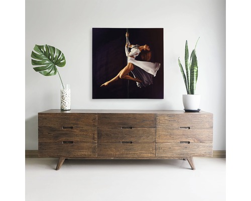 Decor de sufragerie cu comodă din lemn, plante de interior și o pictură pe pânză cu o femeie pe o bară.