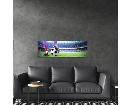Tablou de perete cu motiv fotbalistic deasupra unei canapele