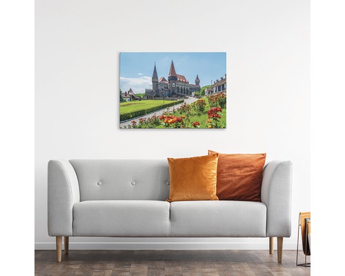 Tablou cu un castel deasupra unei canapele gri
