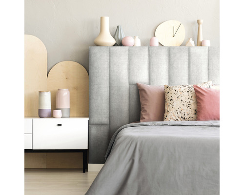 Dormitor cu tăblie tapițată, lenjerie de pat și elemente decorative.