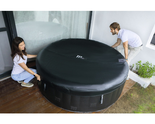 Două persoane mută un jacuzzi gonflabil afară.